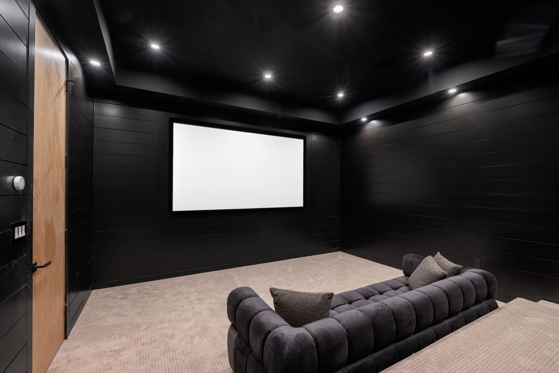 Modern home theater room with large screen and seating